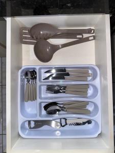 a plastic container filled with utensils in a drawer at Casa ampla e confortavel in Tangara da Serra