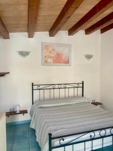 a bedroom with a bed in a room with wooden ceilings at Cozy studio immersed in the countryside in La Maddalena