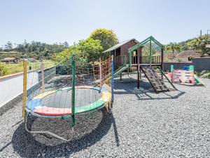 a playground with a slide and a play structure at Casa recém reformada, 3 quartos e com playground in Pomerode