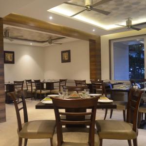 a dining room with tables and chairs in a restaurant at Hotel elegant NYSHAA A Family Hotel Airport PIckup & Drop Free in New Delhi