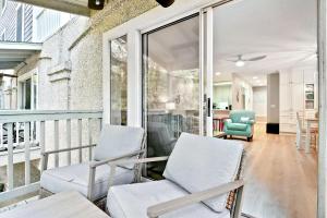a screened porch with two chairs and a table at Salt Shack in Saint Simons Island