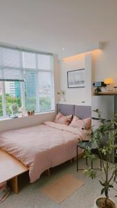 ein Schlafzimmer mit einem großen Bett und zwei Fenstern in der Unterkunft SkyLush from Cozinema in Ho-Chi-Minh-Stadt