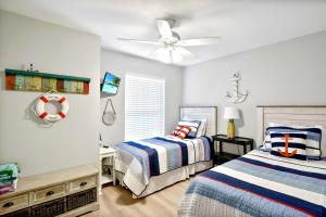 a bedroom with two beds and a ceiling fan at Salt Shack in Saint Simons Island