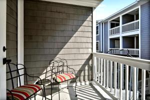 a balcony with two chairs and a table at Salt Shack in Saint Simons Island