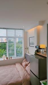 ein Schlafzimmer mit einem Bett vor einem Fenster in der Unterkunft SkyLush from Cozinema in Ho-Chi-Minh-Stadt