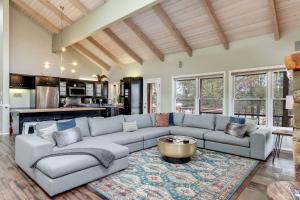 a living room with a couch and a table at Sleeps 30, Riverfront, HotTub, PoolTable, DiscGolf in Three Rivers