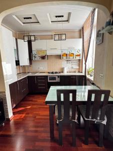cocina con mesa de cristal y 2 sillas en Квартира на Шевченка, en Kamianets-Podilskyi