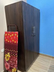 Un armario de madera con una maleta al lado. en Confort moderno, cerca de todo, en Fernando de la Mora