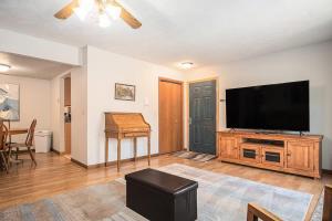 sala de estar con TV de pantalla plana en un centro de entretenimiento de madera en Cozy Home with Comfort & Prime Location & King Bed, en Omaha
