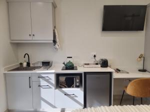 a white kitchen with a sink and a counter at Alice in Wonderland in Kimberley +2 photos