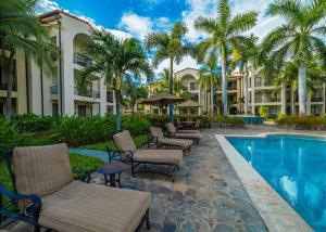 a resort with a pool and chairs and palm trees at Pacifico L1115 in Coco