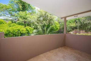 Un balcón vacío con vista a los árboles. en The Cove 10 2br Condo Walk To Ocotal Beach, en Ocotal
