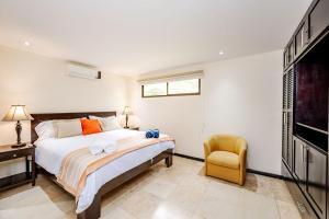 Un dormitorio con una cama y una silla amarilla. en Cove #9 1br Ocotal Beach Condo 2 Guests, en Ocotal 11 fotos más