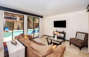 sala de estar con sofá, TV y piscina en Cove #9 1br Ocotal Beach Condo 2 Guests, en Ocotal