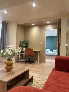 una sala de estar con una mesa y una silla en L'Olivier - appartement cozy au centre de Poitiers, en Poitiers