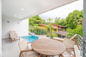 a balcony with a table and chairs and a pool at Los Mangos #3 in Coco