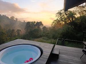 a bath tub on a deck with a view of a forest at Glamping Bosque de helechos, privacidad y cercanía in Manizales