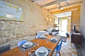 a living room with a table and a brick wall at Eight Point Living Br6 in Birgu