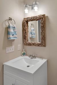 a bathroom with a sink and a mirror at Salt Shack in Saint Simons Island +29 photos