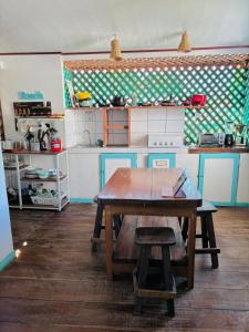 a kitchen with a wooden table and a kitchen with a counter at Soul Rebel Hostel in Puerto Viejo