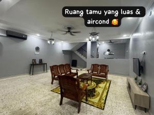 a living room with a dining table and chairs at ZAHINs HOMESTAY in Kuantan