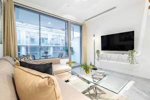 Una sala de estar con un sofá y una ventana grande. en Private Rooftop Jacuzzi - Duplex - Masdar City, en Abu Dabi 36 fotos más