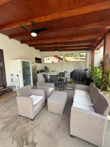 eine Terrasse mit weißen Korbstühlen und einem Tisch in der Unterkunft 2 Boho Villa El Sunzal Private Pool BBQ Paradise in El Sunzal