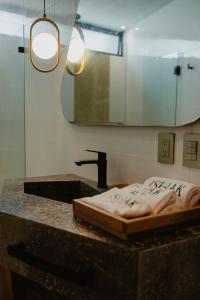 Un mostrador de baño con un lavabo y un espejo. en Ishak Galmoing boutique, en Tequila