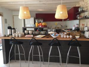 a kitchen with a counter with three bar stools at Barrica Lodge Hotel in Santa Cruz