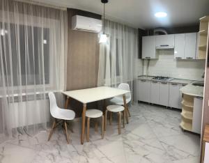 a kitchen with a table and some chairs and a table at Одеська 129 in Golta