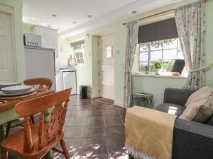 a kitchen and living room with a table and a couch at Figgy Cottage in Ripon