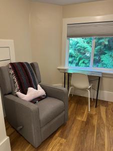 a living room with a chair and a table at Vancouver West Shaughnessy Maison in Vancouver