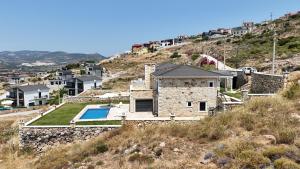 una casa de piedra en una colina con piscina en Foça Taş Villa, en Izmir