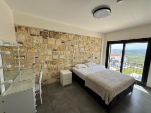 1 dormitorio con pared de piedra, cama y ventana en Foça Taş Villa, en Izmir 28 fotos más