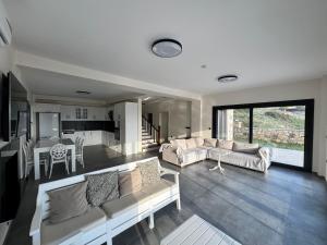 Una sala de estar con dos sofás y una cocina. en Foça Taş Villa, en Izmir
