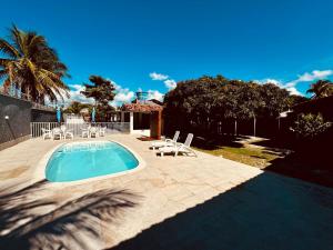 a swimming pool with lounge chairs and a palm tree at Casa em bairro nobre de Prado in Prado