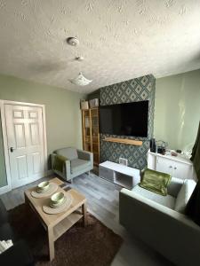 a living room with a couch and a table at Cosy Room Near Train & Hospital  +1 photo