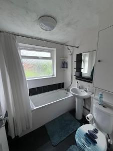 a bathroom with a bath tub and a sink at Cosy Room Near Train & Hospital 