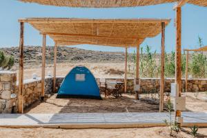 a pavilion with a blue tent in the desert at Coralli Camping in Livadakia