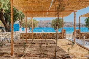 a wooden pavilion with a view of the water at Coralli Camping in Livadakia