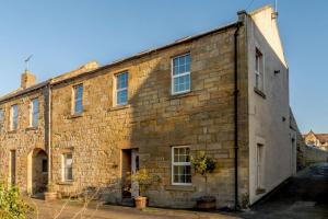 an old brick building with windows on the side at Waters Edge - Warkworth in Warkworth