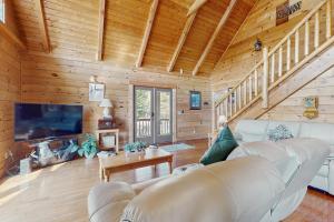 a living room with a couch and a tv in a log cabin at Lazy Bear Lodge in Sevierville