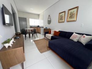 a living room with a blue couch and a table at Residencial jardim bougainville in Sinop