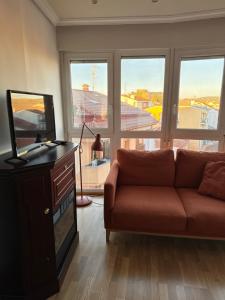 a living room with a couch and a television at El Rincón del Marqués in Las Navas del Marqués