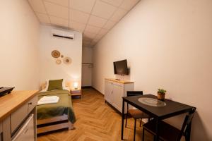 a small room with a bed and a table and a television at Airport Lux Motel Balice in Szczyglice
