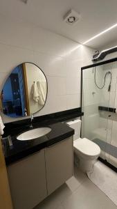 a bathroom with a sink and a toilet and a mirror at Studio Moderno e Aconchegante | Pajuçara - Maceió in Maceió
