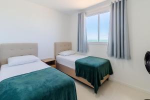 イタパリカにある2Q, Suite com TV, Shopping Boulevard, Vista para Mar, Ed Palmer, NOMDSのベッドが2つと窓があるホテルの部屋