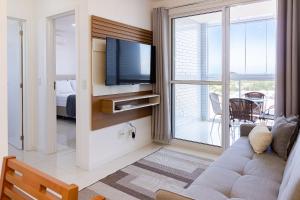 イタパリカにある2Q, Suite com TV, Shopping Boulevard, Vista para Mar, Ed Palmer, NOMDSのソファとテレビのあるリビングルーム