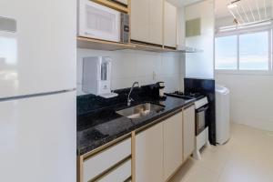 イタパリカにある2Q, Suite com TV, Shopping Boulevard, Vista para Mar, Ed Palmer, NOMDSのシンクと冷蔵庫のある小さなキッチン