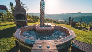 a wooden tub filled with water in a field at Holiday Home Hygge Nova in Grabrovnik